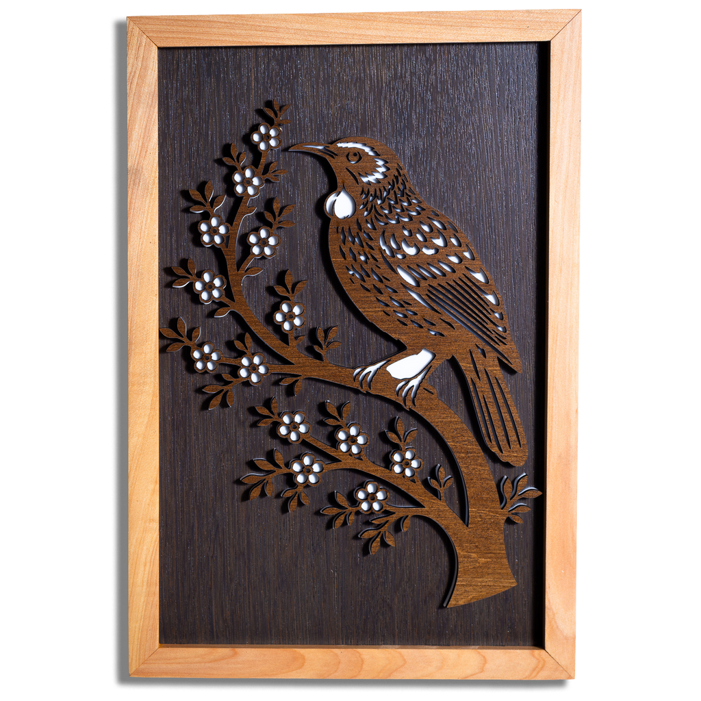 Tūī layered timber wall art in a macrocarpa frame, front view